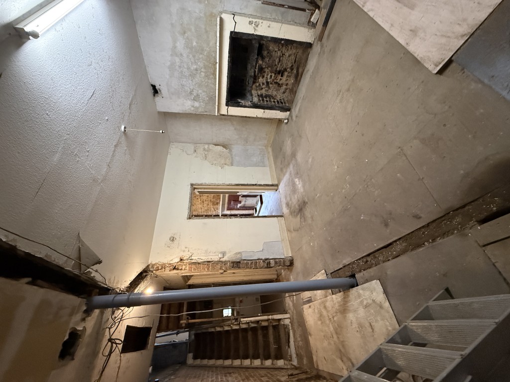 Lot: 82 - MIXED RESIDENTIAL AND COMMERCIAL BUILDING WITH POTENTIAL - View of basement room with staircase to ground floor and fireplace